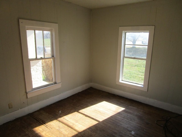 unfurnished room with dark hardwood / wood-style flooring and plenty of natural light