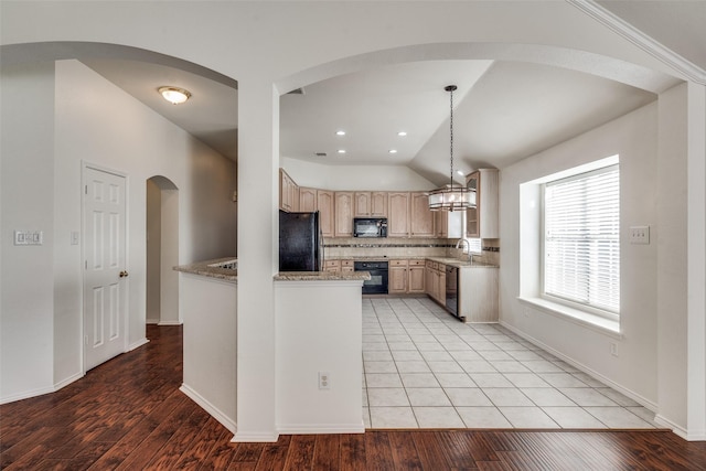 kitchen with vaulted ceiling, hanging light fixtures, black appliances, backsplash, and light brown cabinets