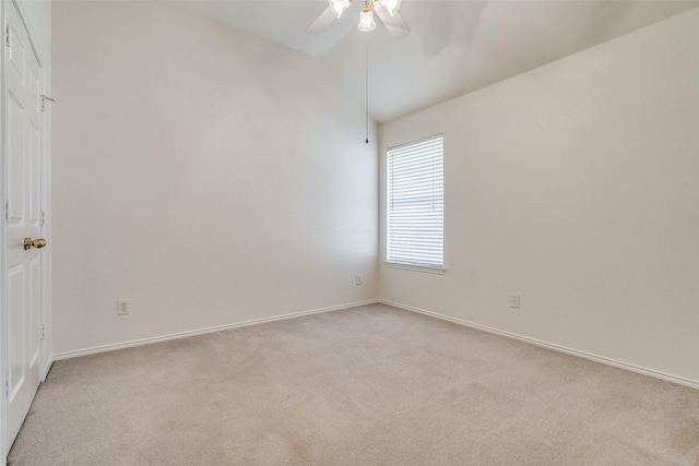 spare room featuring ceiling fan, light carpet, and lofted ceiling