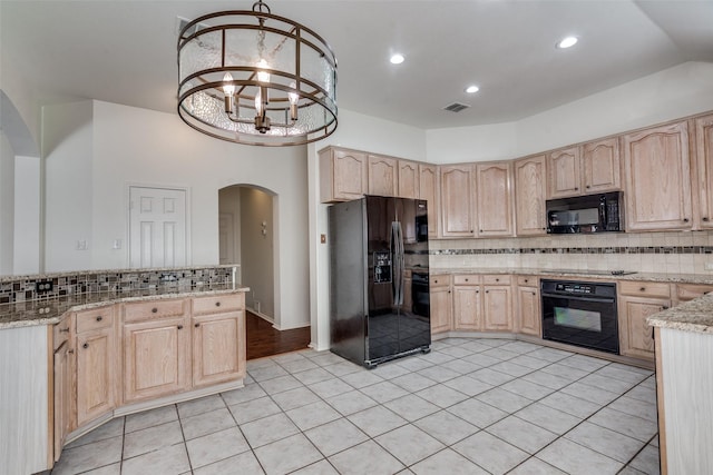 kitchen featuring decorative light fixtures, light brown cabinetry, black appliances, and tasteful backsplash