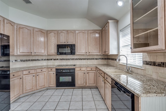 kitchen featuring light stone counters, light brown cabinetry, black appliances, light tile patterned flooring, and sink