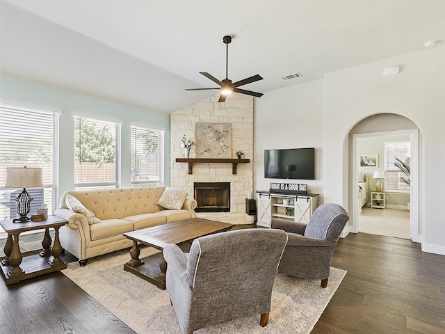 living room featuring lofted ceiling, a fireplace, dark wood-type flooring, and ceiling fan