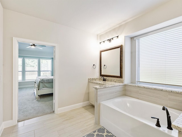 bathroom with ceiling fan, a tub, and vanity