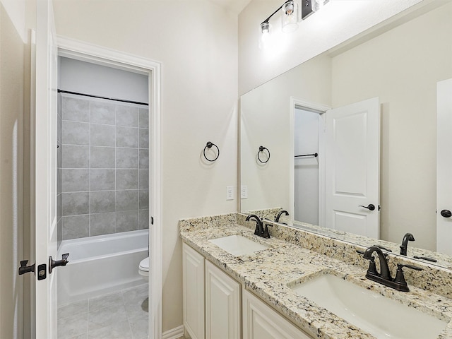 full bathroom with toilet, tiled shower / bath, tile patterned floors, and vanity