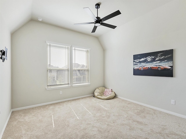 carpeted spare room featuring ceiling fan and lofted ceiling