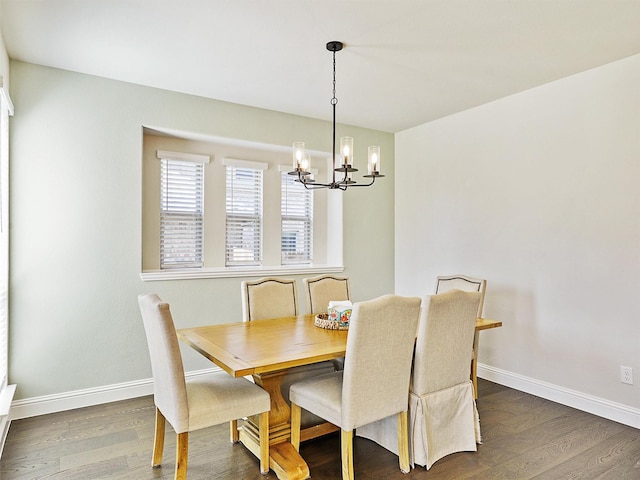 dining area featuring dark hardwood / wood-style flooring and an inviting chandelier