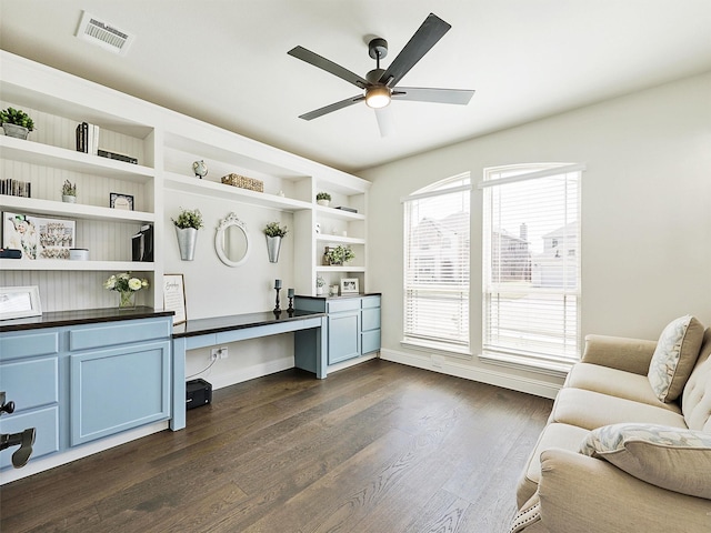 office area featuring built in desk, dark hardwood / wood-style flooring, and ceiling fan