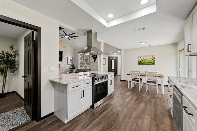 kitchen with light stone counters, stainless steel appliances, white cabinets, and island range hood