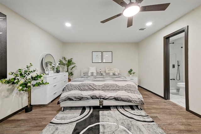 bedroom with ceiling fan, ensuite bathroom, and hardwood / wood-style flooring