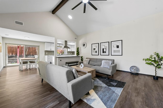 living room with high vaulted ceiling, dark hardwood / wood-style floors, ceiling fan, and beam ceiling