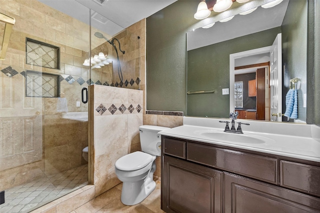 bathroom featuring a textured wall, toilet, a stall shower, vanity, and tile patterned floors