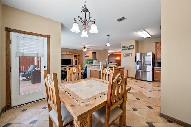 dining area featuring ceiling fan with notable chandelier