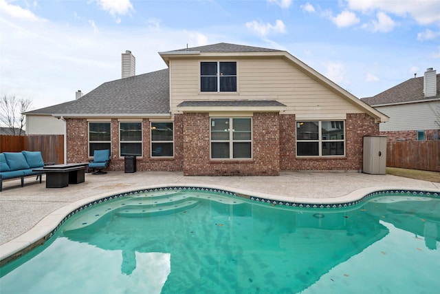 view of pool with a patio area and an outdoor living space with a fire pit