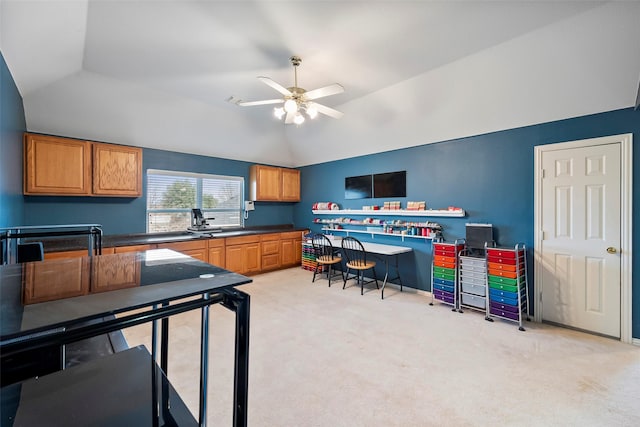 kitchen with dark countertops, light colored carpet, vaulted ceiling, and ceiling fan