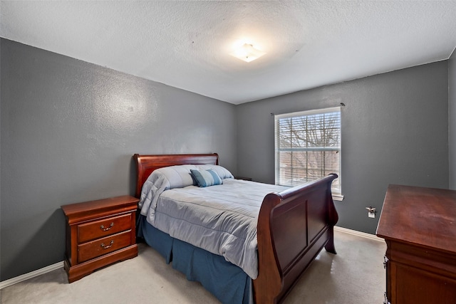 bedroom featuring a textured ceiling and light carpet