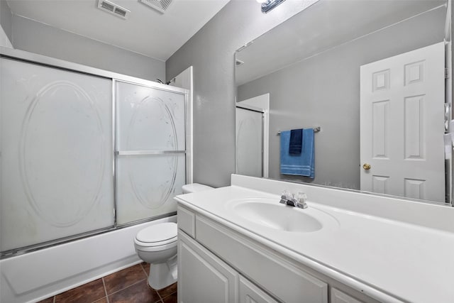 full bathroom featuring vanity, toilet, bath / shower combo with glass door, and tile patterned flooring