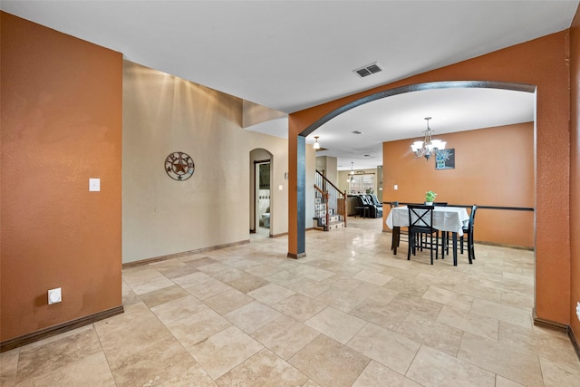 interior space featuring visible vents, arched walkways, baseboards, an inviting chandelier, and stairs