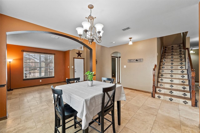 dining room with arched walkways, visible vents, stairway, an inviting chandelier, and baseboards