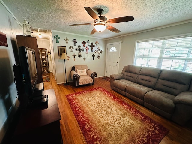 living room with hardwood / wood-style flooring, a textured ceiling, ceiling fan, and crown molding