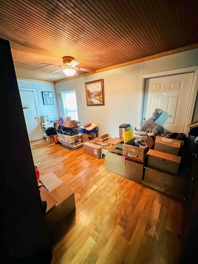 interior space with wooden ceiling, hardwood / wood-style floors, ceiling fan, and crown molding