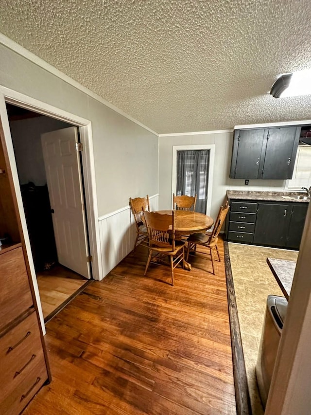 dining area featuring a textured ceiling, hardwood / wood-style floors, and sink