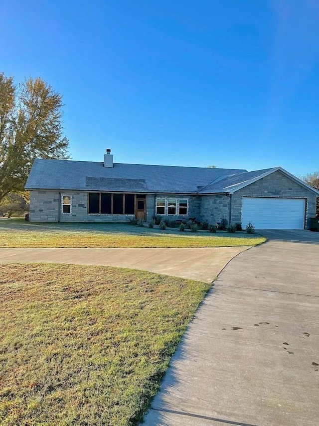 view of front of house with a front yard, driveway, and a chimney