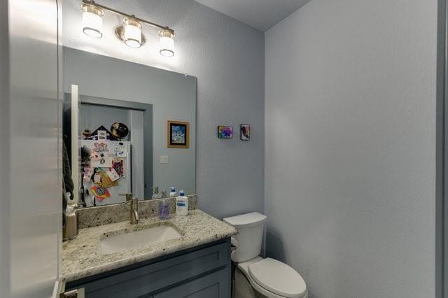 half bathroom with toilet and vanity