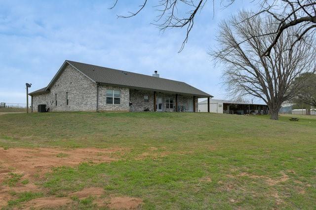 exterior space featuring a lawn and cooling unit