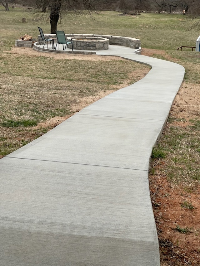 surrounding community featuring an outdoor fire pit and a yard