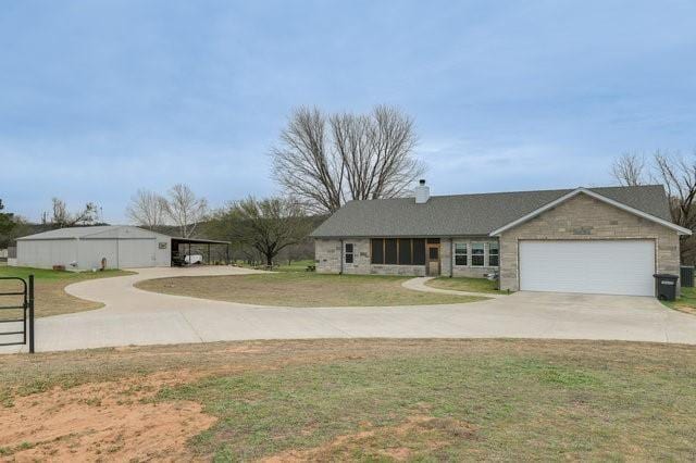 single story home featuring a garage, concrete driveway, a chimney, and a front yard