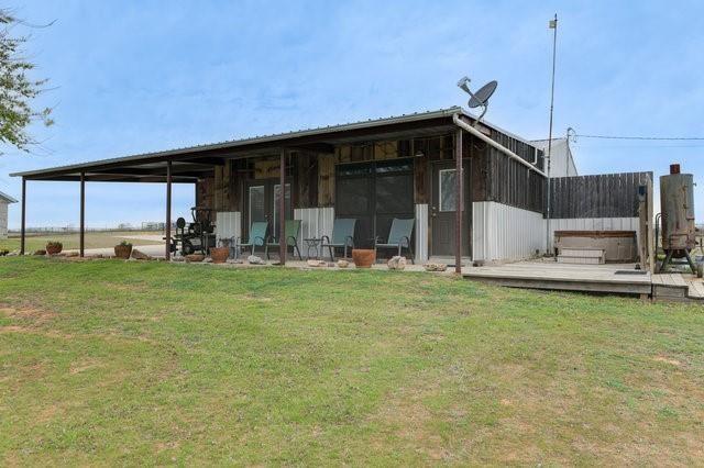 back of property featuring a lawn and a wooden deck