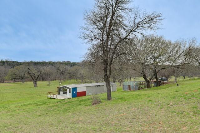 view of yard featuring a rural view and an outdoor structure