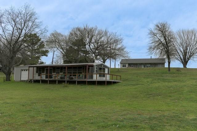 rear view of house with a yard and an outdoor structure