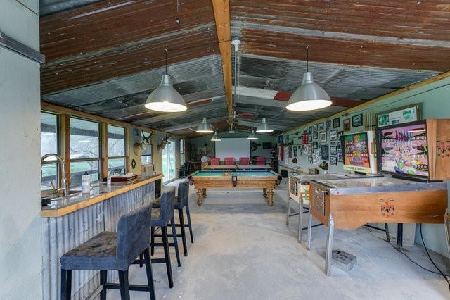 game room featuring lofted ceiling, concrete floors, a sink, and billiards