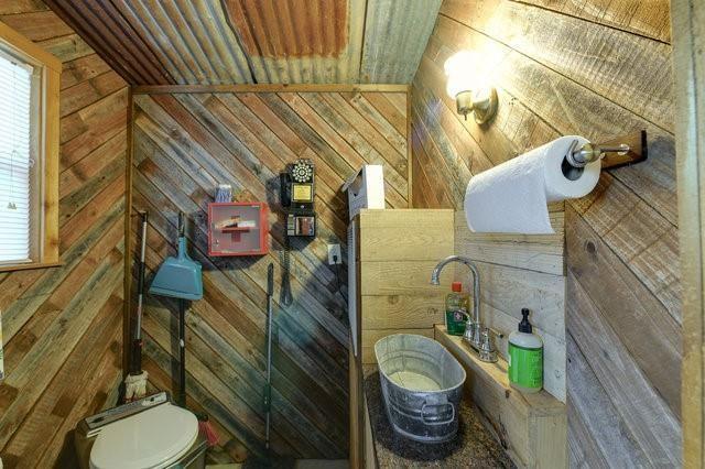 bathroom with wooden walls and toilet