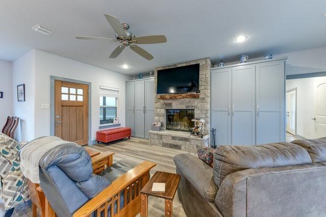 living room featuring recessed lighting, a fireplace, visible vents, a ceiling fan, and light wood finished floors