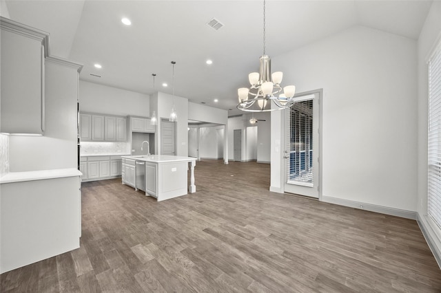 kitchen with pendant lighting, sink, an island with sink, stainless steel dishwasher, and a chandelier