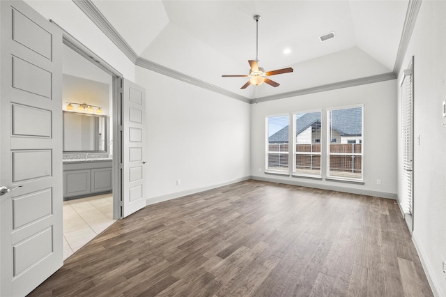 interior space featuring crown molding, a raised ceiling, and light wood-type flooring