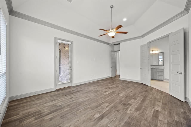 unfurnished bedroom featuring connected bathroom, crown molding, dark hardwood / wood-style floors, a raised ceiling, and access to exterior