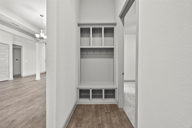 mudroom with wood-type flooring and a chandelier