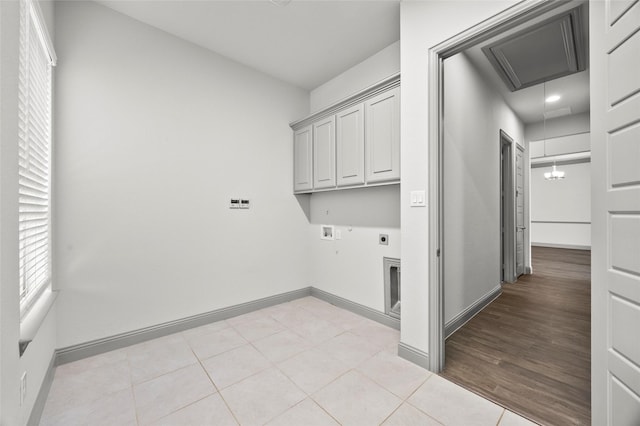 clothes washing area featuring cabinets, hookup for an electric dryer, hookup for a washing machine, and light tile patterned floors