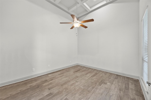 unfurnished room with ceiling fan, coffered ceiling, beam ceiling, and light hardwood / wood-style flooring