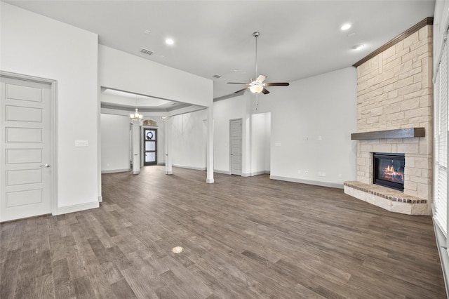 unfurnished living room with a large fireplace, ceiling fan with notable chandelier, and dark hardwood / wood-style floors