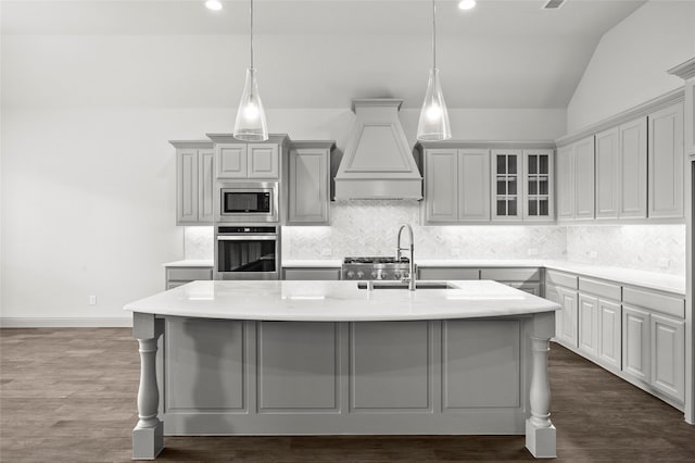 kitchen featuring stainless steel appliances, vaulted ceiling, gray cabinets, and sink