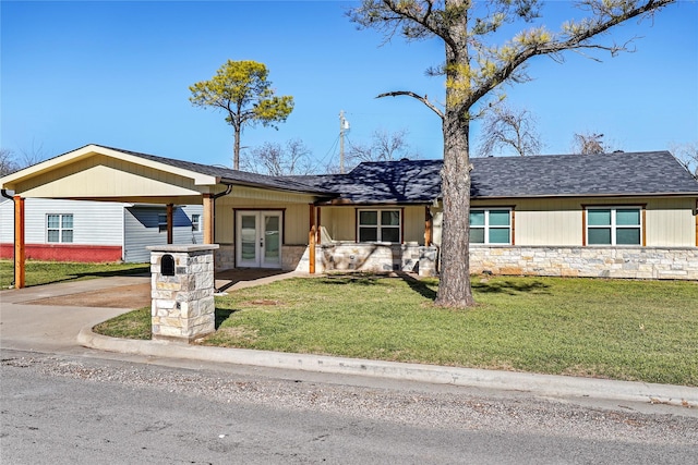 ranch-style home featuring french doors, a carport, and a front lawn