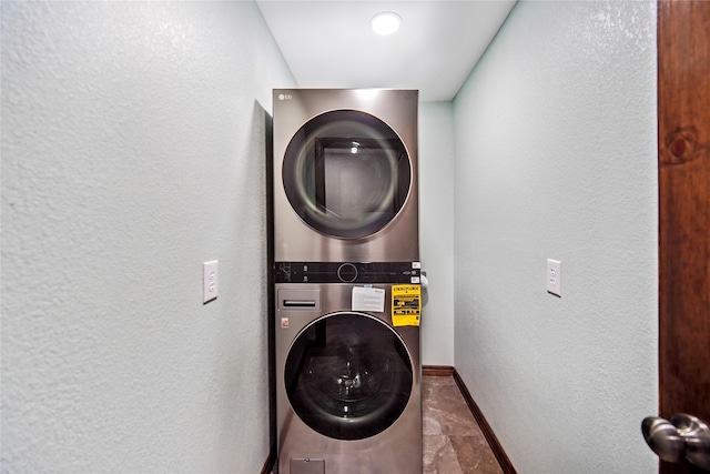 washroom with stacked washer / dryer and tile patterned floors