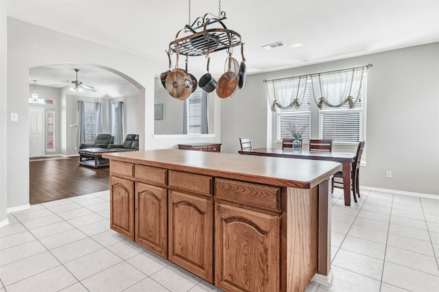 kitchen with ceiling fan, light tile patterned floors, and a kitchen island