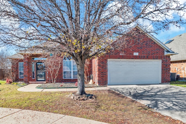 view of front of home featuring cooling unit, a garage, and a front yard