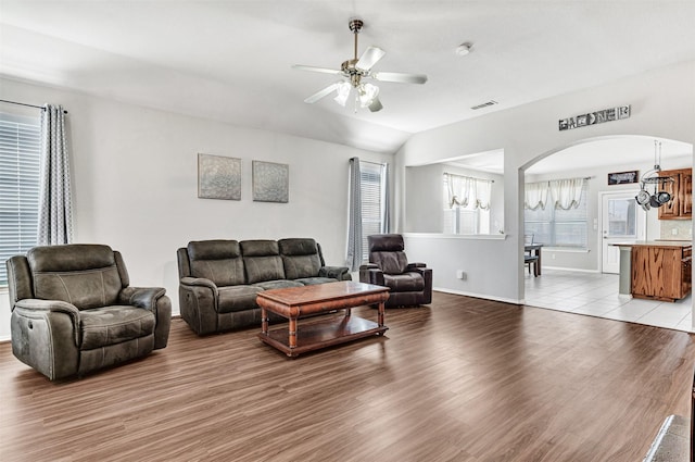 living room with light hardwood / wood-style floors, lofted ceiling, and ceiling fan