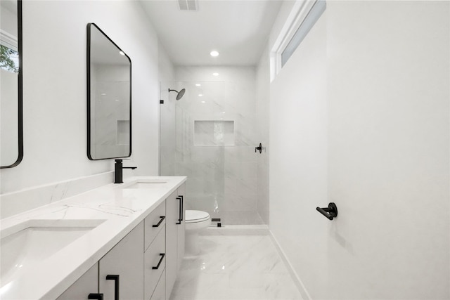 bathroom featuring tiled shower, a wealth of natural light, vanity, and toilet